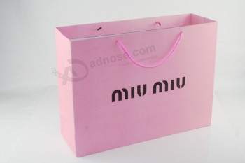 Bolsas de compras de papel de color rosa con mango