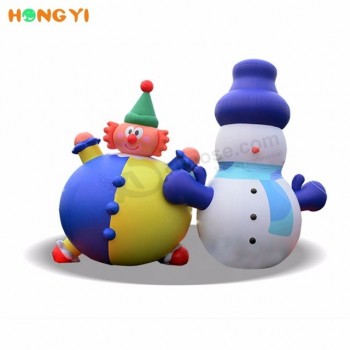 Buiten opblaasbare cartoon grappige clown en hoed met schattige sneeuwpop