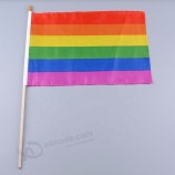 bandeiras vivas da bandeira do arco-íris do orgulho gay da cor vívida com polo de madeira