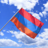 рука, размахивающая печатным флагом флага полиэстера Армении