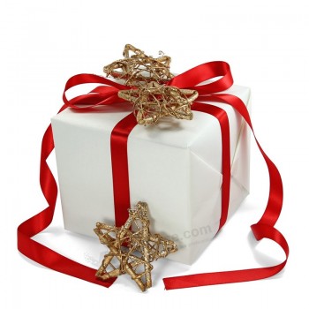 クリスマスのためのリボンと白い地上の紙箱