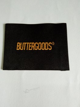 Wholesale customized high-end Taffeta Quality Black Background Orange Text Clothing Woven Label
