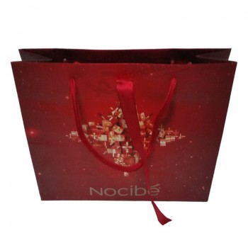 赤いリボンとカスタムデザインの紙のショッピングバッグ