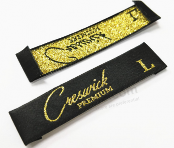 L'etichetta dell'abbigliamento cuce su etichette tessute con fili d'oro