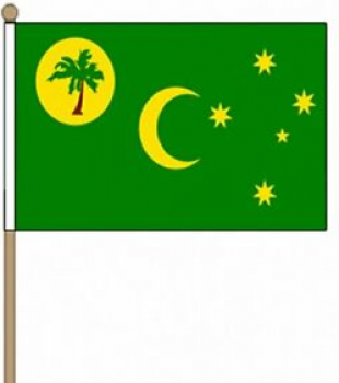ココ諸島を応援するファンがスポーツ用の旗を手に