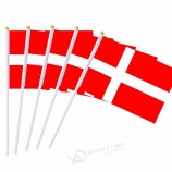 デンマーク国の手が棒で旗を振って開催