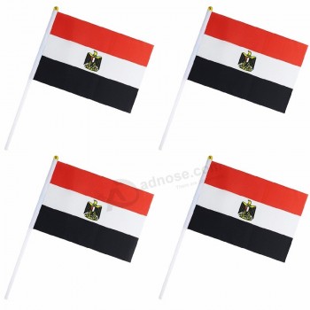 mão pequena do pólo plástico que acena a bandeira de Egito para aplaudir