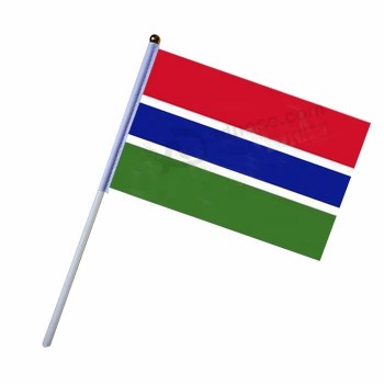 Holzstange und Kunststoffstange Gambia Hand wehende Landesflagge