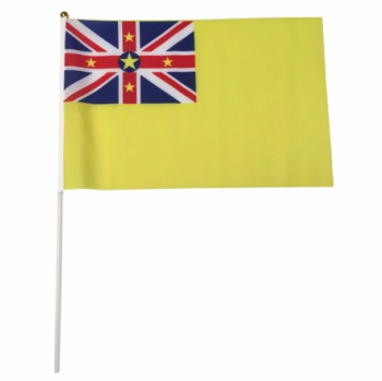 usine en gros niue main agitant bâton drapeau