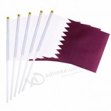 Fã acenando mini bandeiras do qatar de mão