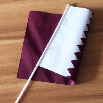 Drapeau personnalisé du Qatar tenu à la main pour encourager le drapeau de poignée de main du Qatar