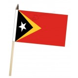 timor-leste (timor-leste) mão grande, acenando uma bandeira de cortesia