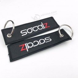 L'etichetta rotonda personalizzata alla moda porta un portachiavi con ricami colorati