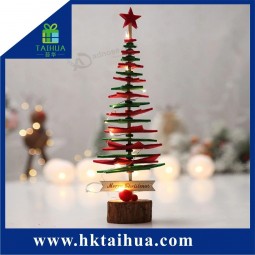 伝統的なクリスマスギフトテーブルの上の人工スリム創造的なクリスマスツリー